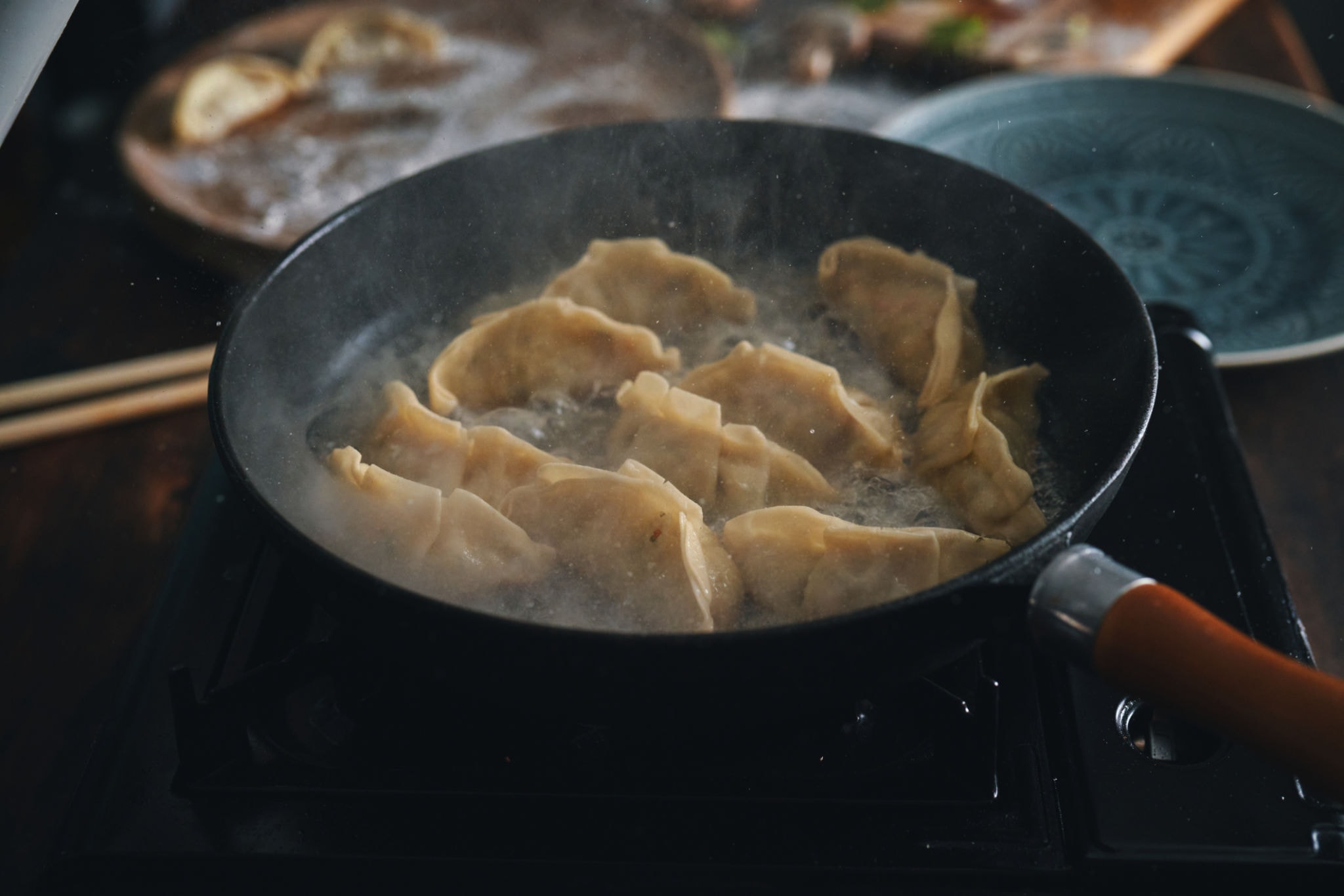 Steaming gyoza dumplings cooking in a pan